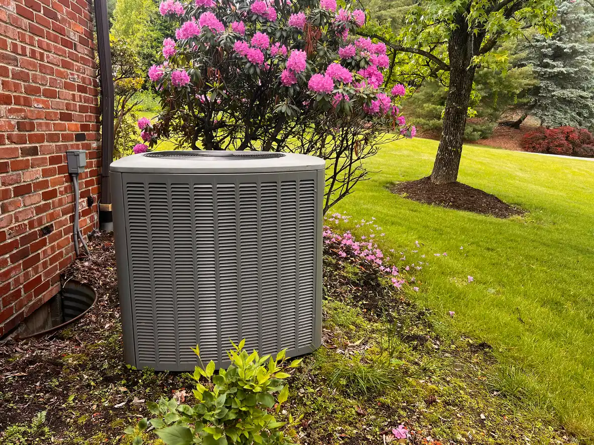 Outdoor AC unit beside a home during spring and summer HVAC maintenance.