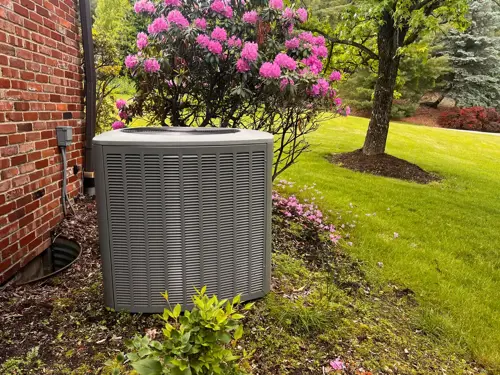 Outdoor AC unit beside a home during spring and summer HVAC maintenance.