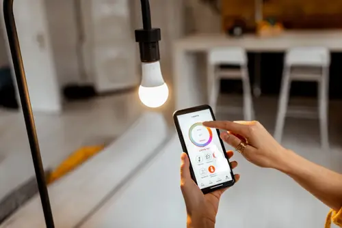 A person using a phone app to control their smart lights in their home.